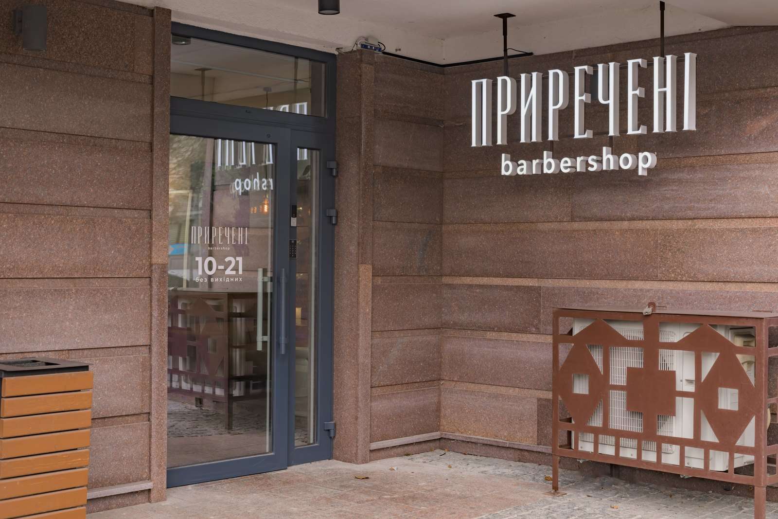 Скляні двері з годинами роботи 10–21 і вивіска ПРИРЕЧЕНІ barbershop на фасаді, Золотоустівська 25, Київ